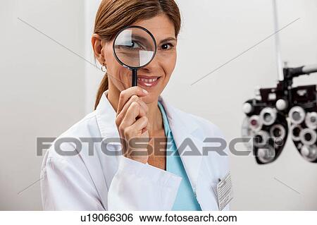 Doctor looking through magnifying glass View Large Photo Image Stock Photograph - Doctor looking through magnifying glass. Fotosearch