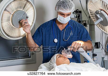 Picture - Doctor putting oxygen tube. Fotosearch