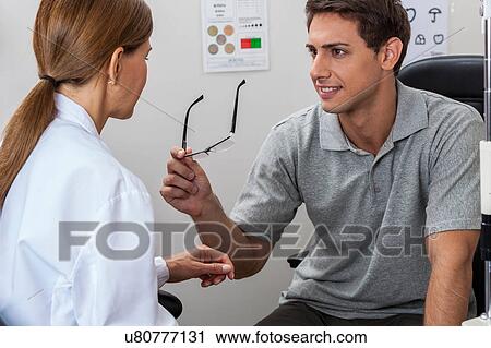 Doctor showing the glasses View Large Photo Image Stock Image - Doctor showing the glasses. Fotosearch