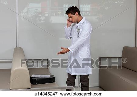 Doctor talking on phone View Large Photo Image Stock Photo - Doctor talking on phone. Fotosearch