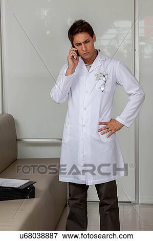 Doctor talking on phone View Large Photo Image Stock Photo - Doctor talking on phone. Fotosearch