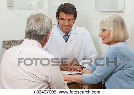 Stock Photography - Elder couple visiting the doctor. Fotosearch