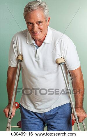 Stock Photograph - elder man using a crutches. Fotosearch