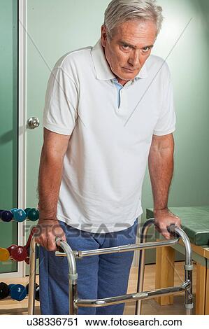Stock Image - ELder man using a walker. Fotosearch