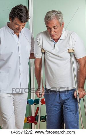 Elder man with his doctor rehabiliting View Large Photo Image Stock Image - Elder man with his doctor rehabiliting. Fotosearch