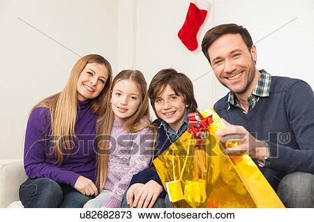 Stock Image - Family sitting together in christmas. Fotosearch