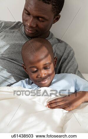 Stock Image - Father and children sleeping in the bed. Fotosearch