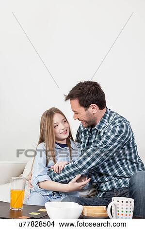 Picture - Father and daughter giving a hug in the breakfast. Fotosearch