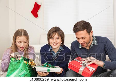 Father with his sons open his present for christmas View Large Photo Image Stock Photo - Father with his sons open his present for christmas. Fotosearch