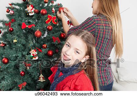 Stock Image - Girl beside the christmas tree. Fotosearch