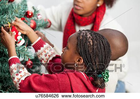 Girl decorating the christmas tree View Large Photo Image Stock Photograph - Girl decorating the christmas tree. Fotosearch
