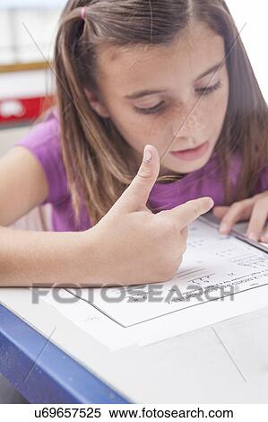 Stock Photography - Girl doing the exercise of math. Fotosearch
