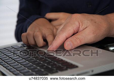 Stock Photography - Girl helping to her grandfather with the computer. Fotosearch