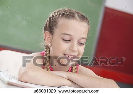 Stock Photo - Girl reading at school and smiling. Fotosearch