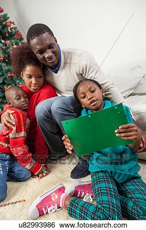 Stock Photograph - Girl reading the letter that wrote to Santa. Fotosearch