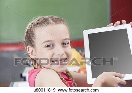 Stock Photo - Girl showing the tablet. Fotosearch