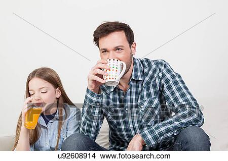 Picture - Girl with his father drinking juice. Fotosearch