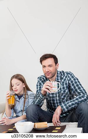 Girl with his father drinking juice View Large Photo Image Stock Photo - Girl with his father drinking juice. Fotosearch