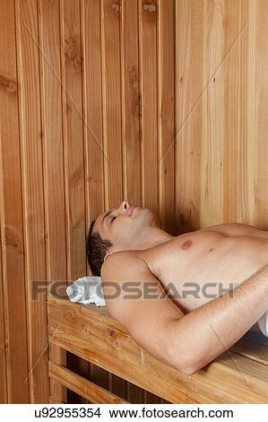 Guy laid inside the sauna View Large Photo Image Picture - Guy laid inside the sauna. Fotosearch