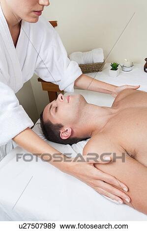 Stock Photo - Guy laid receiving massage. Fotosearch