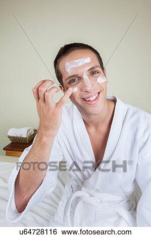 Stock Photograph - Guy putting on face cream. Fotosearch