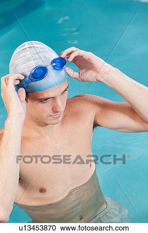 Stock Image - Guy putting on goggles. Fotosearch