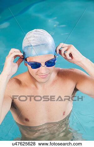 Stock Photo - Guy putting on goggles. Fotosearch