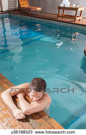 Stock Image - Guy rest in the edge of the pool. Fotosearch