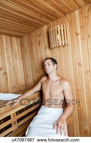 Stock Photo - Guy resting inside the sauna. Fotosearch