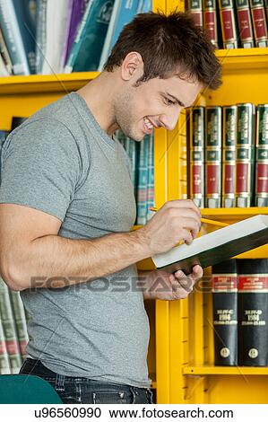 Stock Image - Guy studying with a book. Fotosearch
