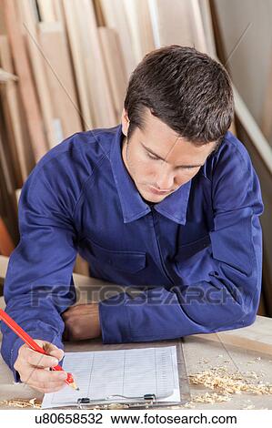 Guy writing in his workshop View Large Photo Image Stock Image - Guy writing in his workshop. Fotosearch