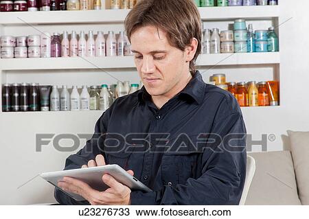 Hairstylist reads in the ipad View Large Photo Image Stock Image - Hairstylist reads in the ipad. Fotosearch