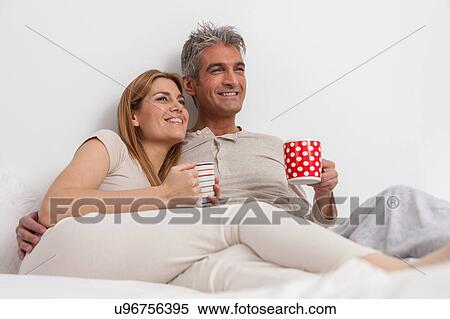 Happy couple drinking coffe in the bed View Large Photo Image Stock Photography - Happy couple drinking coffe in the bed. Fotosearch