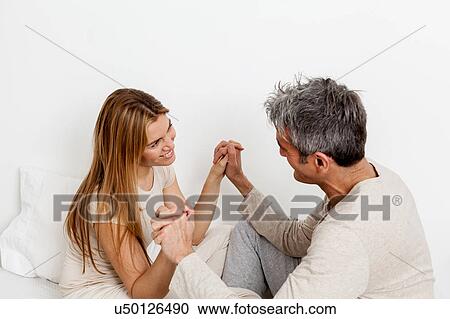 Stock Image - Happy couple having fun in the bed. Fotosearch