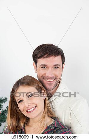 Happy couple hugging himself beside the christmas tree View Large Photo Image Stock Image - Happy couple hugging himself beside the christmas tree. Fotosearch