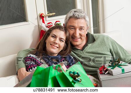 Stock Image - Happy couple in the sofa. Fotosearch