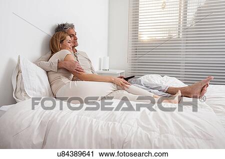 Stock Image - Happy couple lying in the bed. Fotosearch