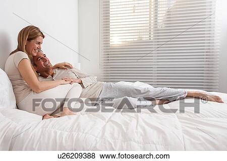 Happy couple lying in the bed View Large Photo Image Stock Photo - Happy couple lying in the bed. Fotosearch