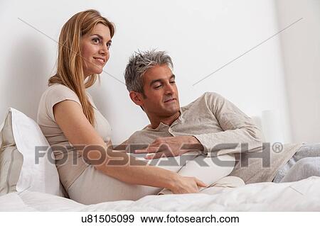Happy couple lying in the bed View Large Photo Image Stock Photo - Happy couple lying in the bed. Fotosearch