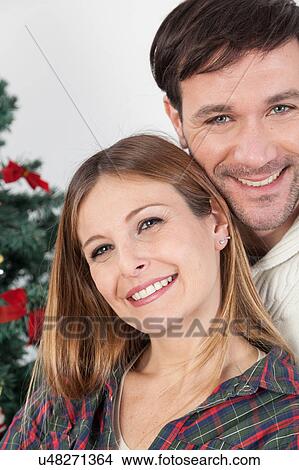Picture - Happy couple smiling in christmas. Fotosearch