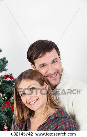 Happy couple smiling in christmas View Large Photo Image Stock Image - Happy couple smiling in christmas. Fotosearch