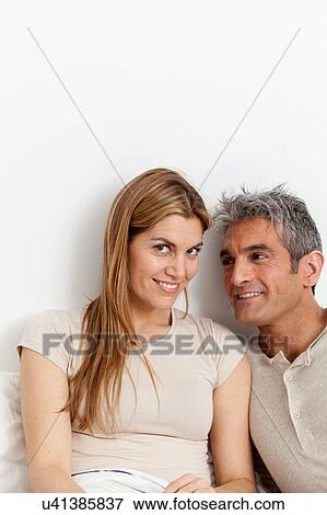 Happy couple viewing a photo album View Large Photo Image Stock Photo - Happy couple viewing a photo album. Fotosearch