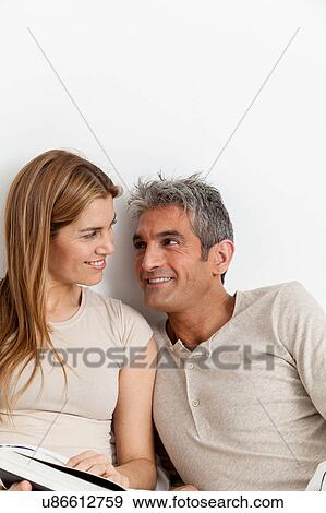 Stock Photo - Happy couple viewing a photo album. Fotosearch