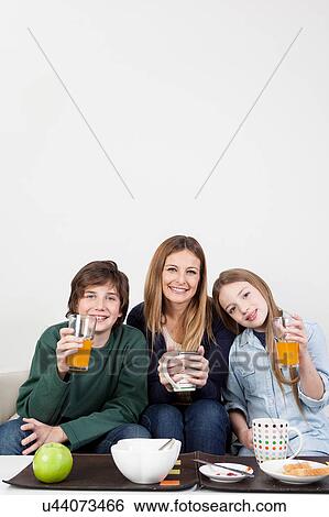 Happy family drinking juice together View Large Photo Image Stock Photograph - Happy family drinking juice together. Fotosearch