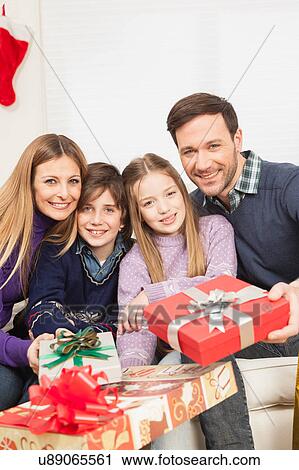 Happy family smiling giving present View Large Photo Image Stock Image - Happy family smiling giving present. Fotosearch