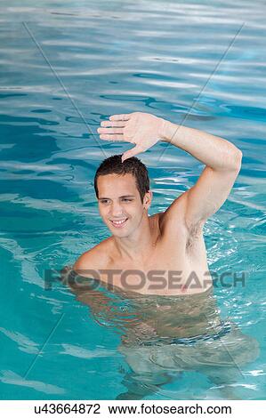 Stock Image - Happy guy exercising in the pool. Fotosearch