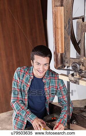 Stock Photography - Happy guy working with wood. Fotosearch