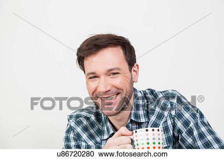 Stock Image - Happy man holding a cupful. Fotosearch
