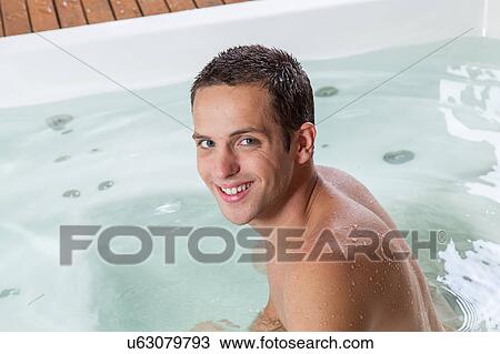 Stock Image - Happy man inside a jacuzzi. Fotosearch