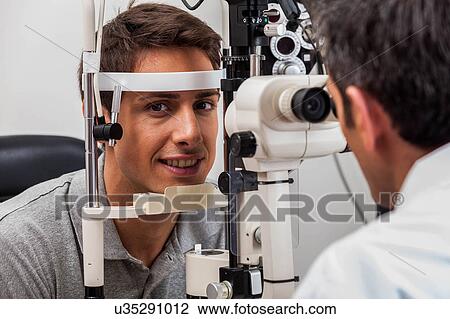 Happy man looking through the keratometer View Large Photo Image Stock Image - Happy man looking through the keratometer. Fotosearch